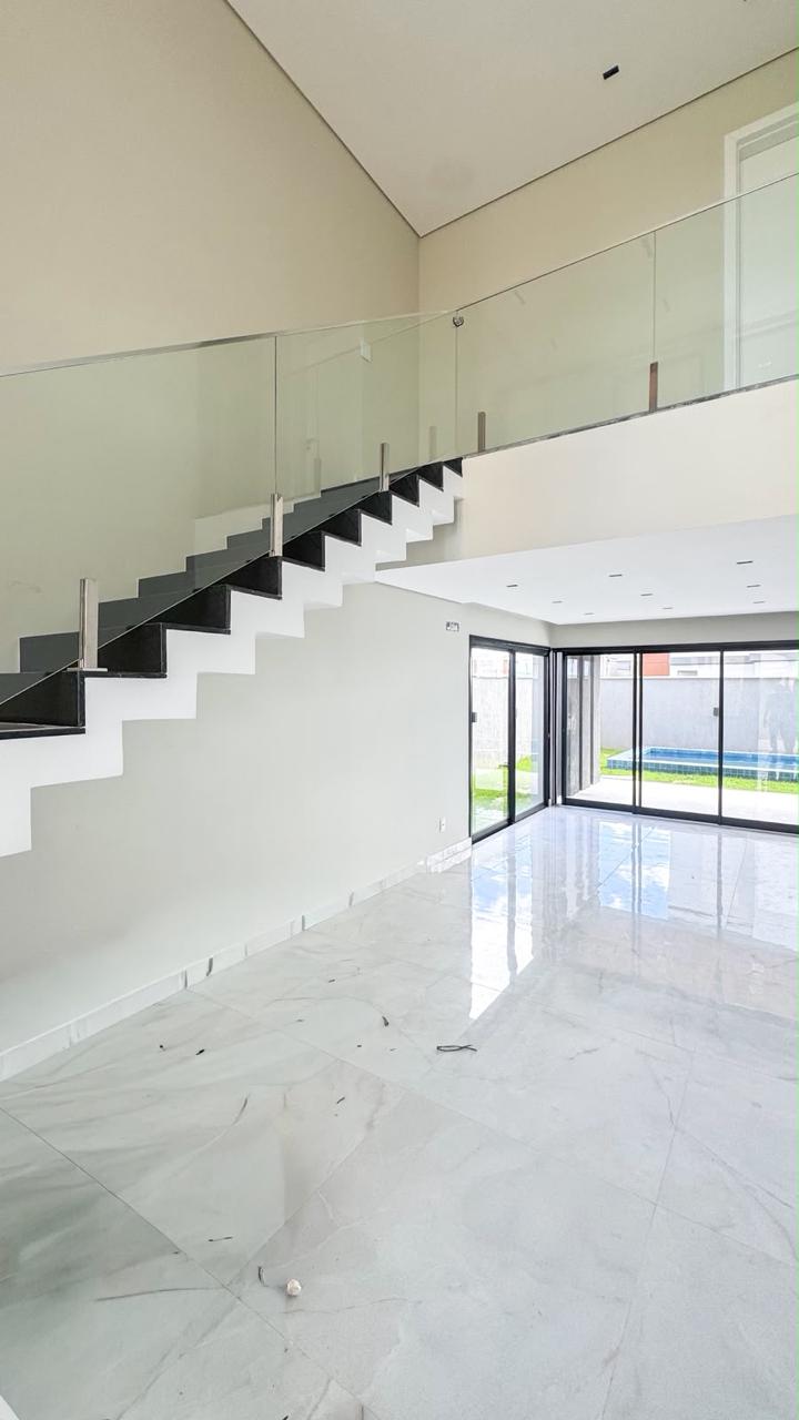 Sala integrada com escada e guarda-corpo em vidro